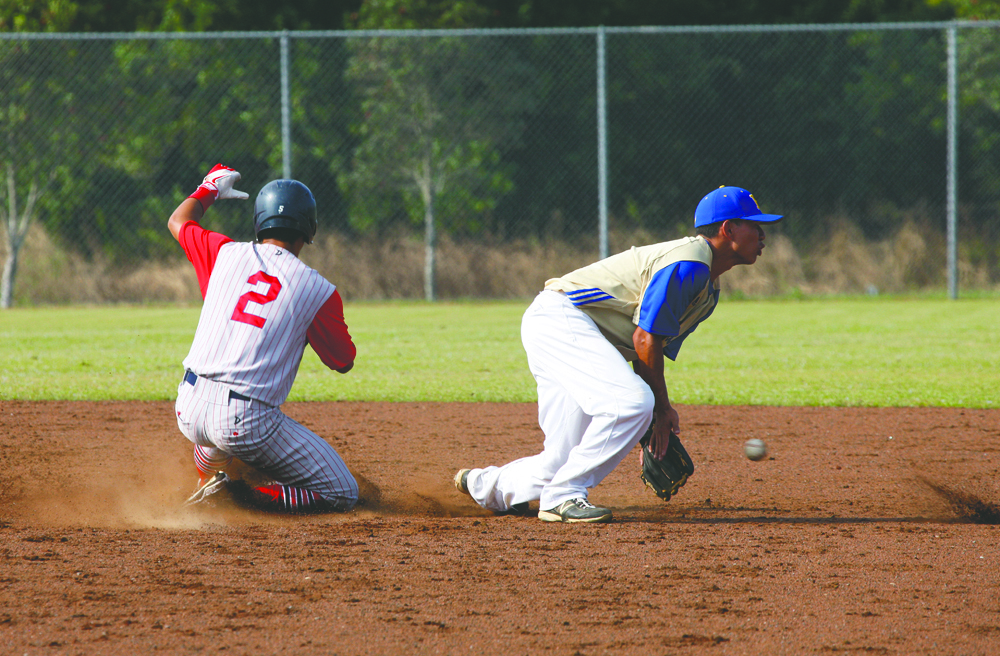 R.W. SMITH/Tribune-Herald Keaau's Rylan Martines slides safely into second as Hilo's Micah Kaaukai fields a throw.