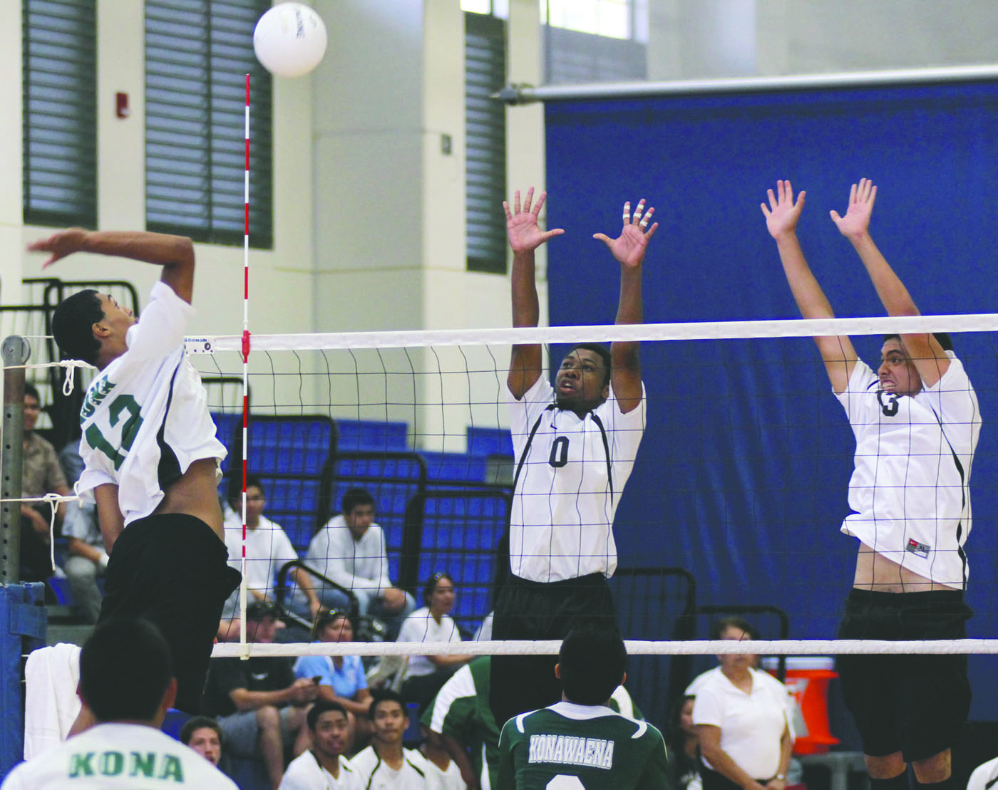 TIM WRIGHT/Tribune-Herald Konawaena's Gabriel Trevino spikes against Pahoa's Caleb Woo-O'Brien, right, and Nick Fisher.