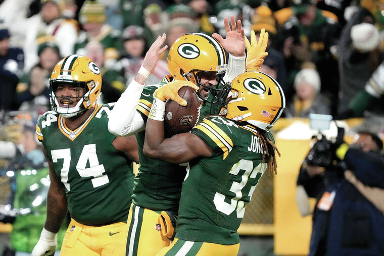 Green Bay Packers' Aaron Jones (33) reaches the end zone for a